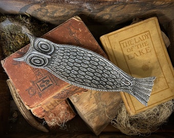 May include: A silver owl-shaped incense burner sits on top of two vintage books. The books are titled "The Lady of the Lake" and "The Library of the World's Best Literature".