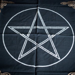 Pu&ograve; includere: Tessuto nero con un pentagramma bianco all'interno di un cerchio. Il tessuto ha un bordo di nodo celtico dorato.