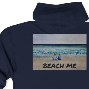 May include: Navy blue hooded sweatshirt with a painting of two people sitting on a beach with the text "Beach Me" printed below the image.