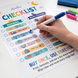 A person uses a blue dry-erase marker to check off an item on a laminated kids morning and night routine checklist sheet.