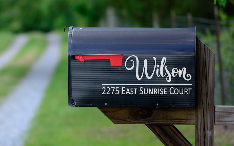 Puede incluir: Buz&oacute;n negro con una pegatina de vinilo blanco que dice "Wilson" y "2275 East Sunrise Court".