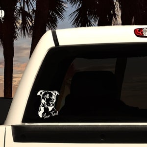 May include: White vinyl decal of a pit bull dog's head with the text "Your Text" underneath. The decal is on the back window of a white pickup truck.