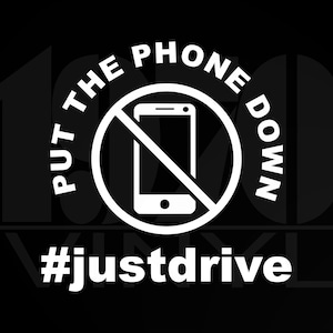May include: White graphic on a black background with a circle and a line through a smartphone. The text reads "Put the phone down #justdrive".
