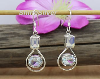May include: Silver dangle earrings with rectangular and oval iridescent gemstones. The earrings have a simple, elegant design with a hook closure. The text "ShineSilver" is visible in the background.