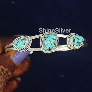 K&ouml;nnte beinhalten: Silberarmband mit drei t&uuml;rkisfarbenen Steinen, die in Silber gefasst sind. Die Steine sind tropfenf&ouml;rmig, quadratisch und tropfenf&ouml;rmig.