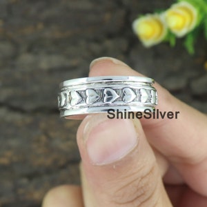 Könnte beinhalten: Ein silberner Ring mit einem Band aus herzförmigen Aussparungen. Der Ring hat ein strukturiertes Design und der Text "ShineSilver" ist auf dem Ring sichtbar.