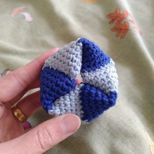 May include: A blue and grey crocheted hair scrunchie.