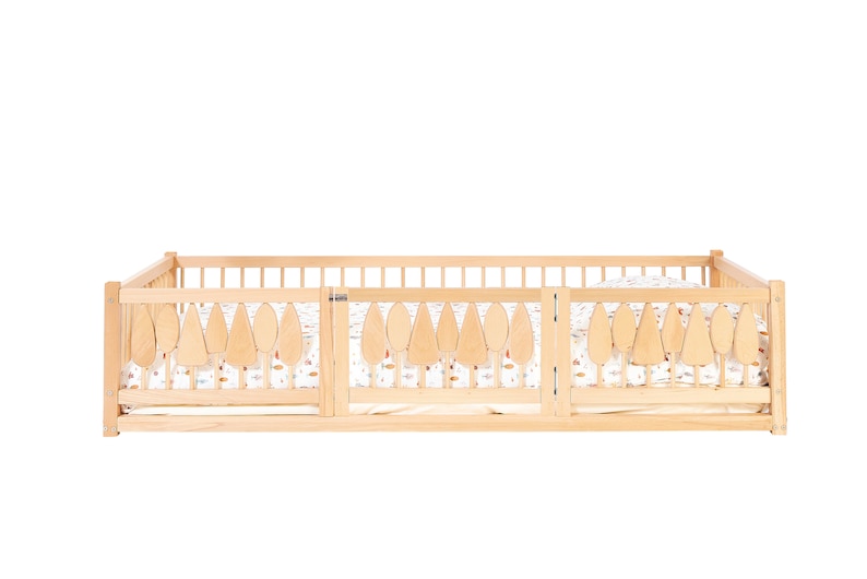 Puede incluir: Un corral de madera con una puerta y una s&aacute;bana estampada en blanco y marr&oacute;n. El corral tiene un dise&ntilde;o de hojas en la parte superior.