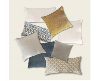 May include: A collection of eight decorative throw pillows in various colors and patterns. The pillows are made of different fabrics, including linen, cotton, and velvet. The patterns include geometric shapes, chevron stripes, and a solid color.