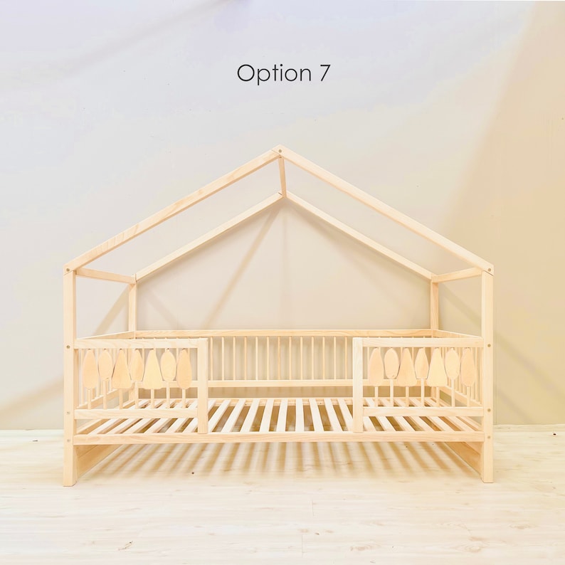May include: A wooden toddler bed with a house-shaped frame and a slatted mattress. The bed has two side rails with decorative cutouts shaped like trees. The text "Option 7" is visible at the top of the image.
