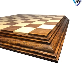 May include: A wooden chessboard with a dark brown frame and a light brown and white checkered playing surface.