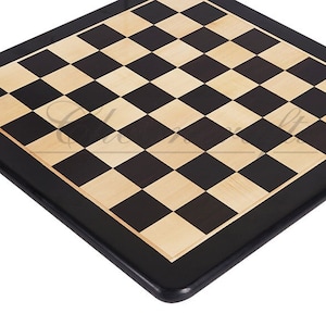 May include: A black and light wood chessboard with a black border. The board is made of wood and has a smooth surface.