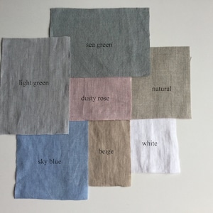 May include: Fabric swatches in various colors, including light green, sea green, dusty rose, natural, beige, white, and sky blue. The swatches are arranged in a grid pattern on a white surface.