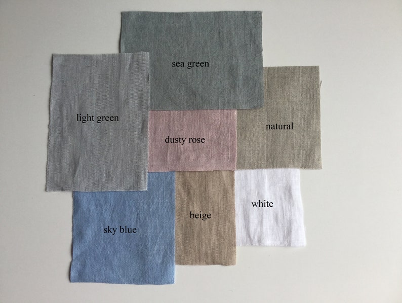 May include: Fabric swatches in various colors, including light green, sea green, dusty rose, natural, beige, white, and sky blue. The swatches are arranged in a grid pattern on a white surface.