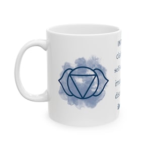 May include: White ceramic mug featuring a blue watercolor design and a geometric symbol. The mug has a handle and text on the side. The design includes the words: INT, clair, self-, imp, dis, in.