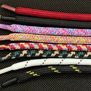 May include: Eight different shoelace styles, numbered 1 through 8, are displayed against a black background. The shoelaces are in various colors and patterns, including red, black, pink, yellow, blue, green, white, and beige.