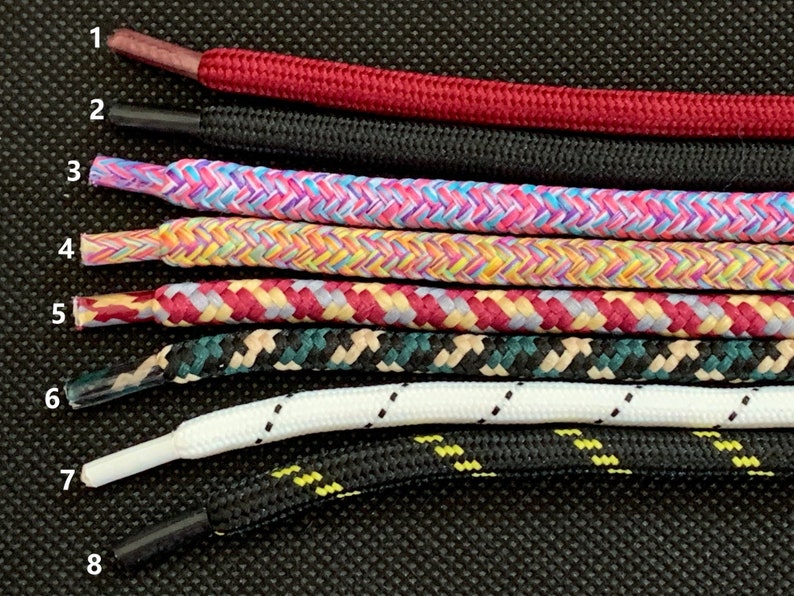 K&ouml;nnte beinhalten: Acht verschiedene Schn&uuml;rsenkel-Stile, nummeriert von 1 bis 8, werden vor einem schwarzen Hintergrund angezeigt. Die Schn&uuml;rsenkel sind in verschiedenen Farben und Mustern, darunter Rot, Schwarz, Pink, Gelb, Blau, Gr&uuml;n, Wei&szlig; und Beige.