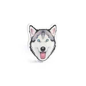 May include: A sticker featuring a cartoon husky dog with blue eyes and a pink tongue sticking out. The dog is looking directly at the viewer.