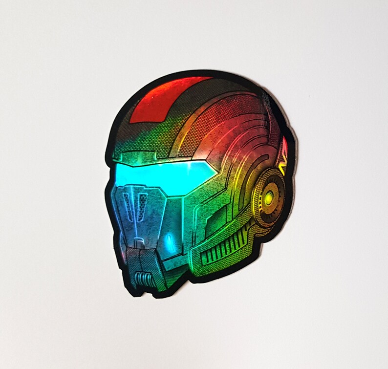 Pode incluir: Um autocolante hologr&aacute;fico de um capacete futurista com viseira. O capacete apresenta um gradiente de cores vermelho, laranja, amarelo, verde e azul. A viseira brilha com uma luz azul brilhante. O design tem uma est&eacute;tica mec&acirc;nica detalhada.