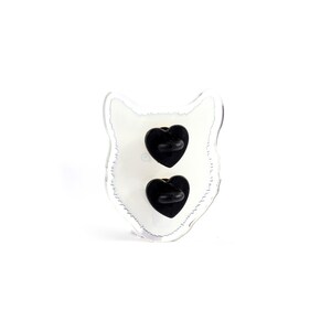 May include: A clear plastic pin back with a white wolf silhouette and two black heart-shaped pin backs.