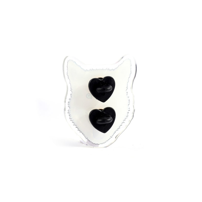 May include: A clear plastic pin back with a white wolf silhouette and two black heart-shaped pin backs.