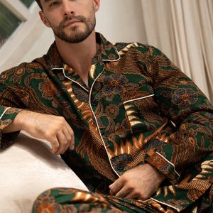 Puede incluir: Conjunto de pijama con estampado verde y marr&oacute;n con ribete blanco. La parte superior de manga larga y los pantalones presentan un dise&ntilde;o floral. El pijama est&aacute; hecho de un material suave y c&oacute;modo.