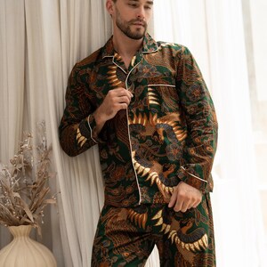 Puede incluir: Conjunto de pijama con estampado verde y marr&oacute;n con ribete blanco. La camisa de manga larga y el pantal&oacute;n presentan un dise&ntilde;o detallado. El pijama es de material suave.