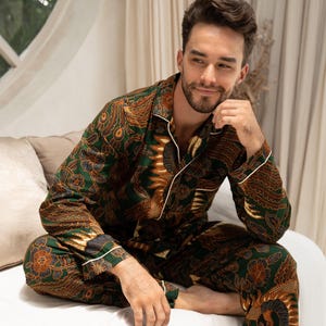 Puede incluir: Conjunto de pijama con estampado verde y marr&oacute;n con ribete blanco. La parte superior de manga larga y los pantalones presentan un dise&ntilde;o detallado y ornamentado. El pijama est&aacute; hecho de un material suave y c&oacute;modo.