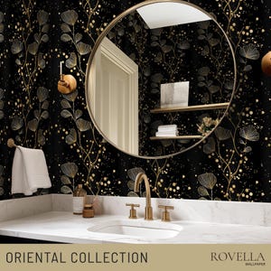 May include: A bathroom with a black and gold floral wallpaper. A round gold mirror hangs above a white sink with gold fixtures. The text "ORIENTAL COLLECTION" is at the bottom of the image.