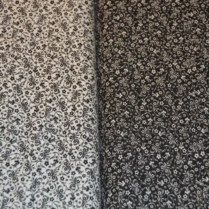 May include: A fabric featuring a dense, repeating pattern of small flowers and swirling vine motifs. The left side displays a white background with black print, while the right side shows a black background with white print, creating a high contrast.