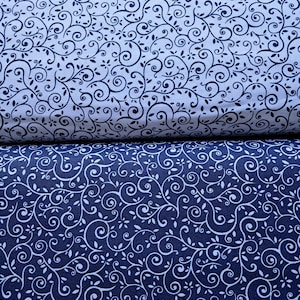 May include: Two folded pieces of fabric featuring a continuous scrolling vine and leaf pattern. The top fabric is white with dark navy blue lines, while the bottom fabric is dark navy blue with white lines, creating a contrasting color scheme.