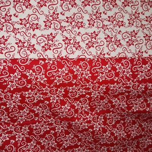May include: A fabric featuring a two-tone floral pattern with a horizontal split. The top section displays red floral and vine motifs on a white background, while the bottom section reverses the color scheme with white floral motifs on a red background.