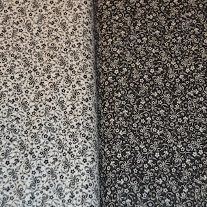 May include: A fabric featuring a dense, repeating pattern of small flowers and swirling vine motifs. The left side displays a white background with black print, while the right side shows a black background with white print, creating a high contrast.