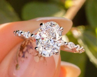Anillo de compromiso ovalado de moissanita con diamante marquesa lateral y diamante redondo en la banda. Anillo de boda de oro blanco de 18k hecho a mano. Regalos de boda personalizados.