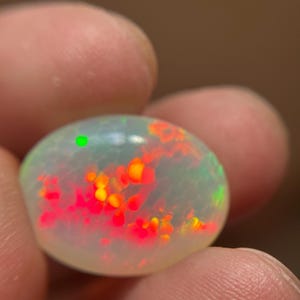 Rare 13-carat oval honeycomb opal loose gemstone with intense multi-color fire.