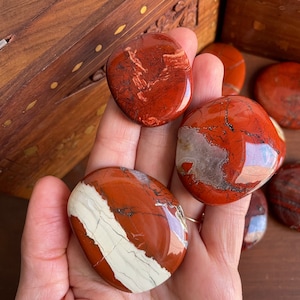 Polished Red Jasper Palm Stone - A vibrant gem for balancing the Root Chakra.