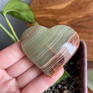 Dive into tranquility with a close-up view of our A Grade Large Green Onyx Heart. Immerse yourself in the soothing energy and premium quality of this exquisite crystal.