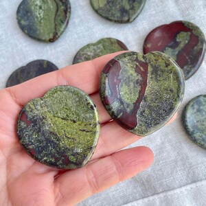May include: A collection of heart-shaped polished stones with a green, red, and black marbled pattern.