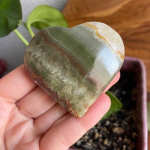 This close-up shot captures the intricate colors and patterns of our Green Onyx Hearts. Perfect for creating a crystal gridding centerpiece to amplify harmony.