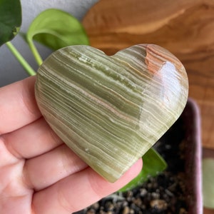 Experience the mesmerizing colors and banding of our 2-inch Green Onyx Heart. Perfect for those seeking emotional balance and positive transformation.