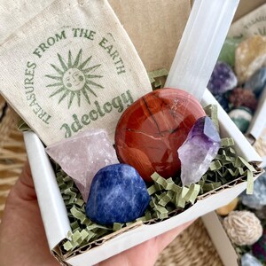 Mini Mystery Crystal Box Contents: May include a delightful mix of crystals, such as a selenite stick, tumbled stone, rough stone, crystal point, and palm stone, along with a hand-stamped muslin pouch for storage. Perfect for beginners!