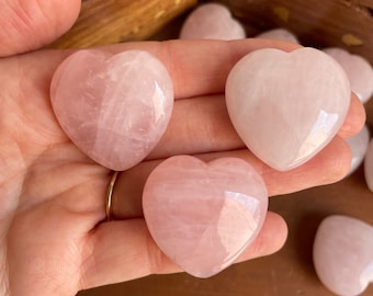 May include: Three pink rose quartz heart shaped stones. The stones are smooth and polished.