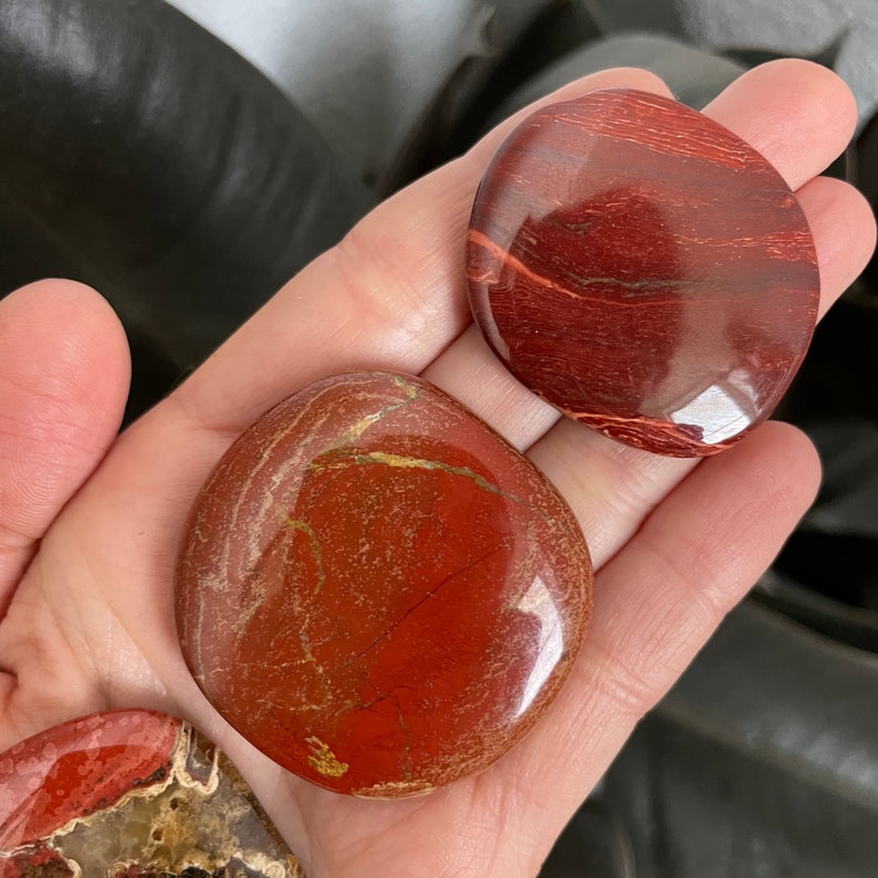 Pu&ograve; includere: Due pietre di diaspro rosso per il palmo della mano, una di colore rosso pi&ugrave; chiaro con venature dorate, l'altra di colore rosso pi&ugrave; scuro e una superficie liscia e lucida.