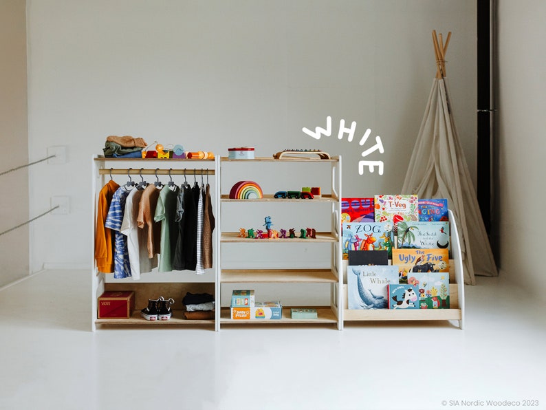 May include: White wooden storage shelves with a hanging rack for clothes. The shelves are filled with children's books and toys. The word "WHITE" is written in white on a white background.