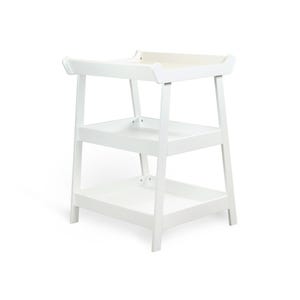 May include: A white wooden changing table with three tiers. The top tier has a raised edge, and the lower tiers are open shelves. The table is designed with a minimalist aesthetic and is suitable for a nursery.