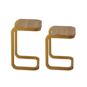 Op de afbeelding: Twee bijzettafels met een modern design. Elke tafel heeft een lichtgekleurd, rechthoekig houten blad en een goudkleurig, gebogen metalen frame. De tafels worden tegen een witte achtergrond getoond.