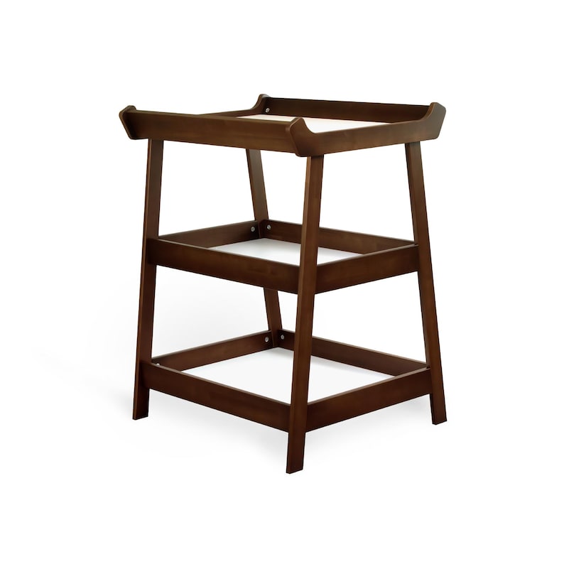 May include: A dark brown wooden changing table. It features a rectangular top with curved edges and two lower shelves. The legs are angled for stability. The design is simple and functional, suitable for a nursery. The measurements are in centimeters.