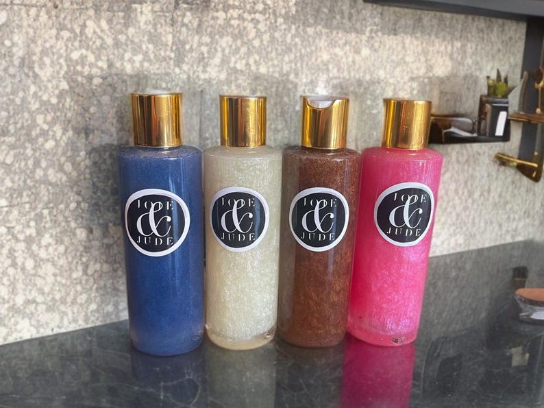 May include: Four bottles of body scrub with gold lids and labels that say "Love & Jude". The bottles are blue, white, brown, and pink.