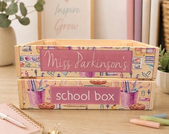 May include: Two wooden school boxes, one on top of the other. The top box has the text "Miss Parkinson's" on a pink background. The bottom box has the text "school box" on a pink background. Both boxes are decorated with school-themed illustrations.