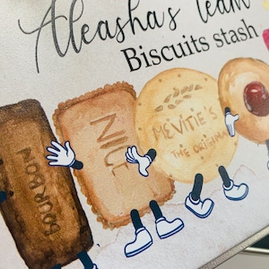 May include: A white metal tin with a cartoon illustration of biscuits with legs and arms. The tin is labelled "Aleeasha's tea Biscuits stash". The biscuits are labelled "Bourbon", "Nice", "McVitie's The Original", and a round biscuit with a red centre.